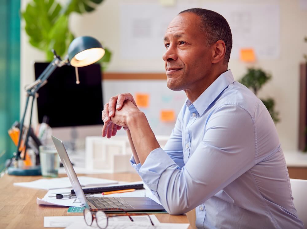 Mature businessman sitting in his office looking to the side