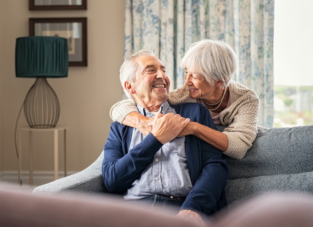 Senior couple hugging sitting on a couch